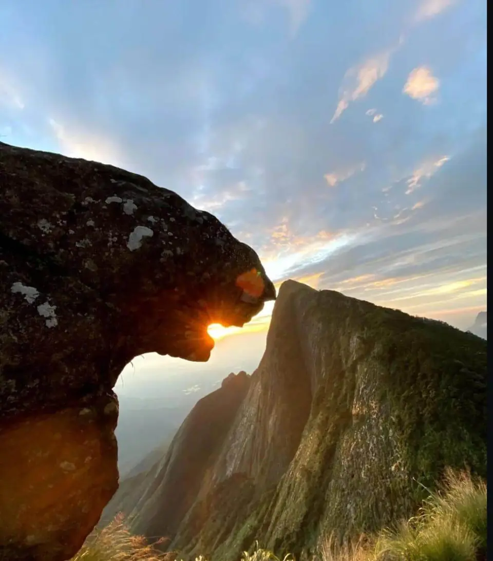 Sun shining through a rock arch on a Kolukkumalai ridge