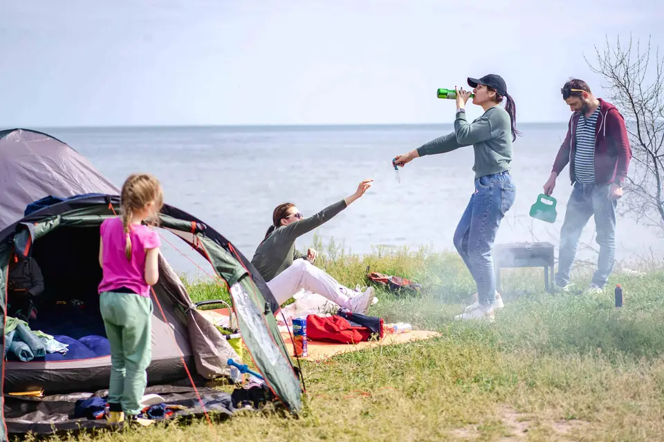Family at a tent campsite beside a lake